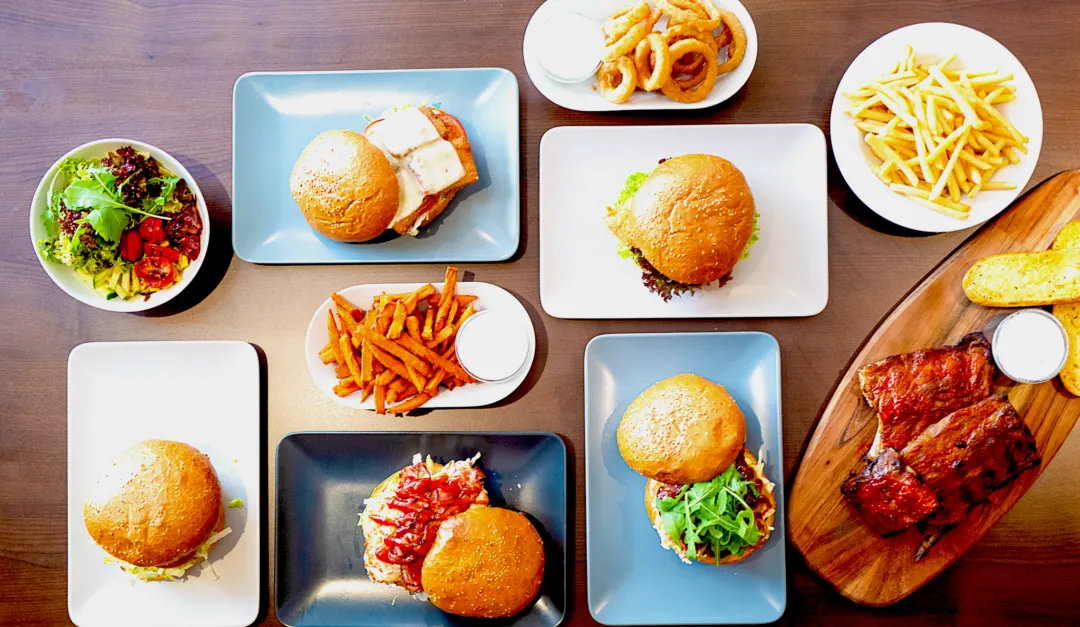 Top view of Harry’s burgers, fries, onion rings, salad and spare ribs